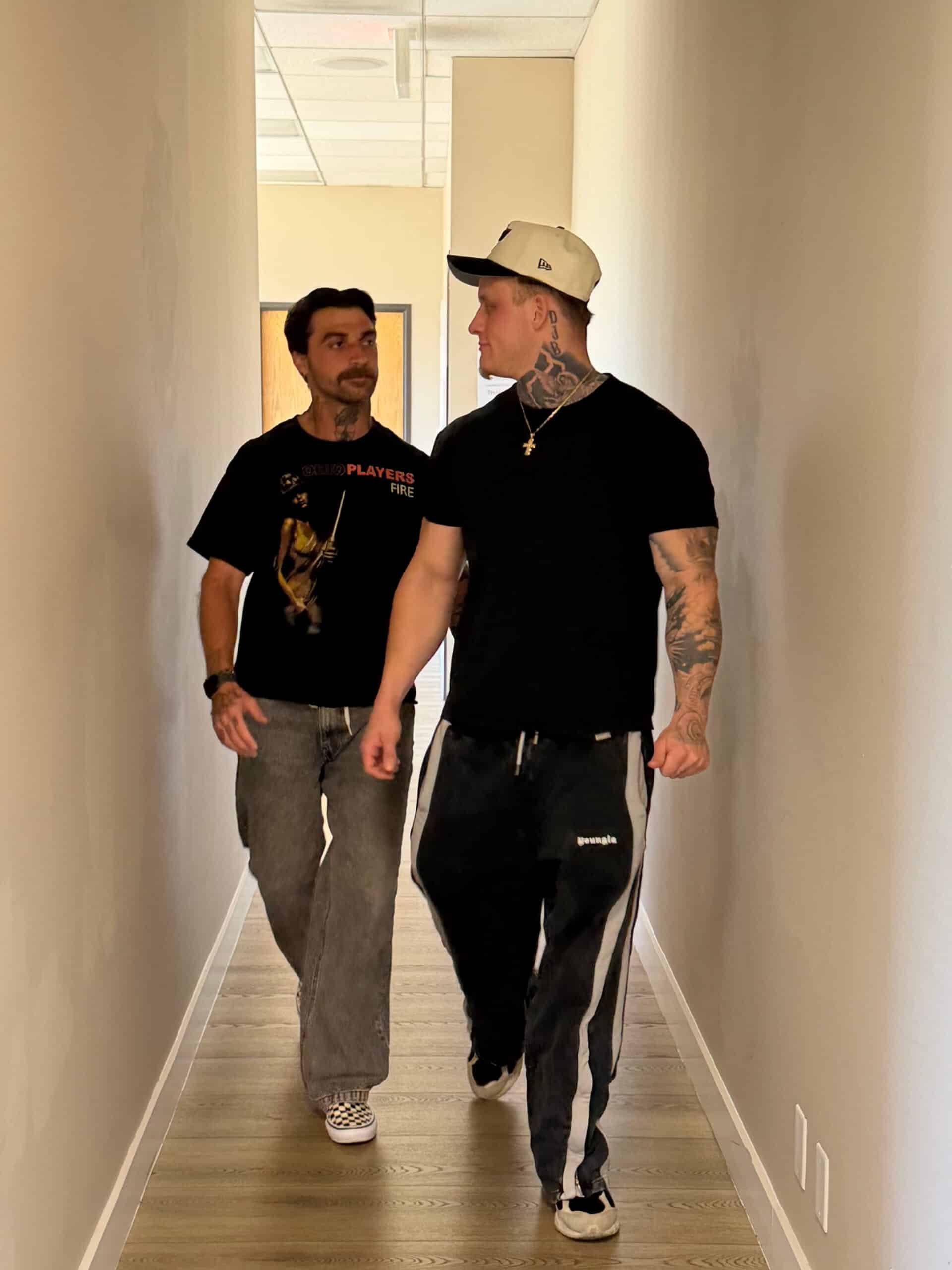 Two people walking down a hallway at Launch To Wellness